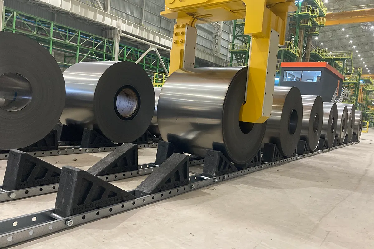 Heavy steel coils supported by engineered coil saddle in a safe coil storage system