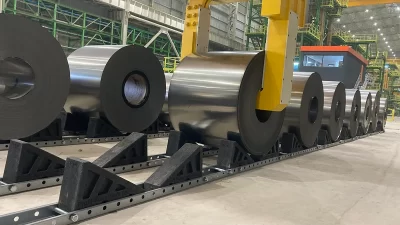 Heavy steel coils supported by engineered coil saddle in a safe coil storage system